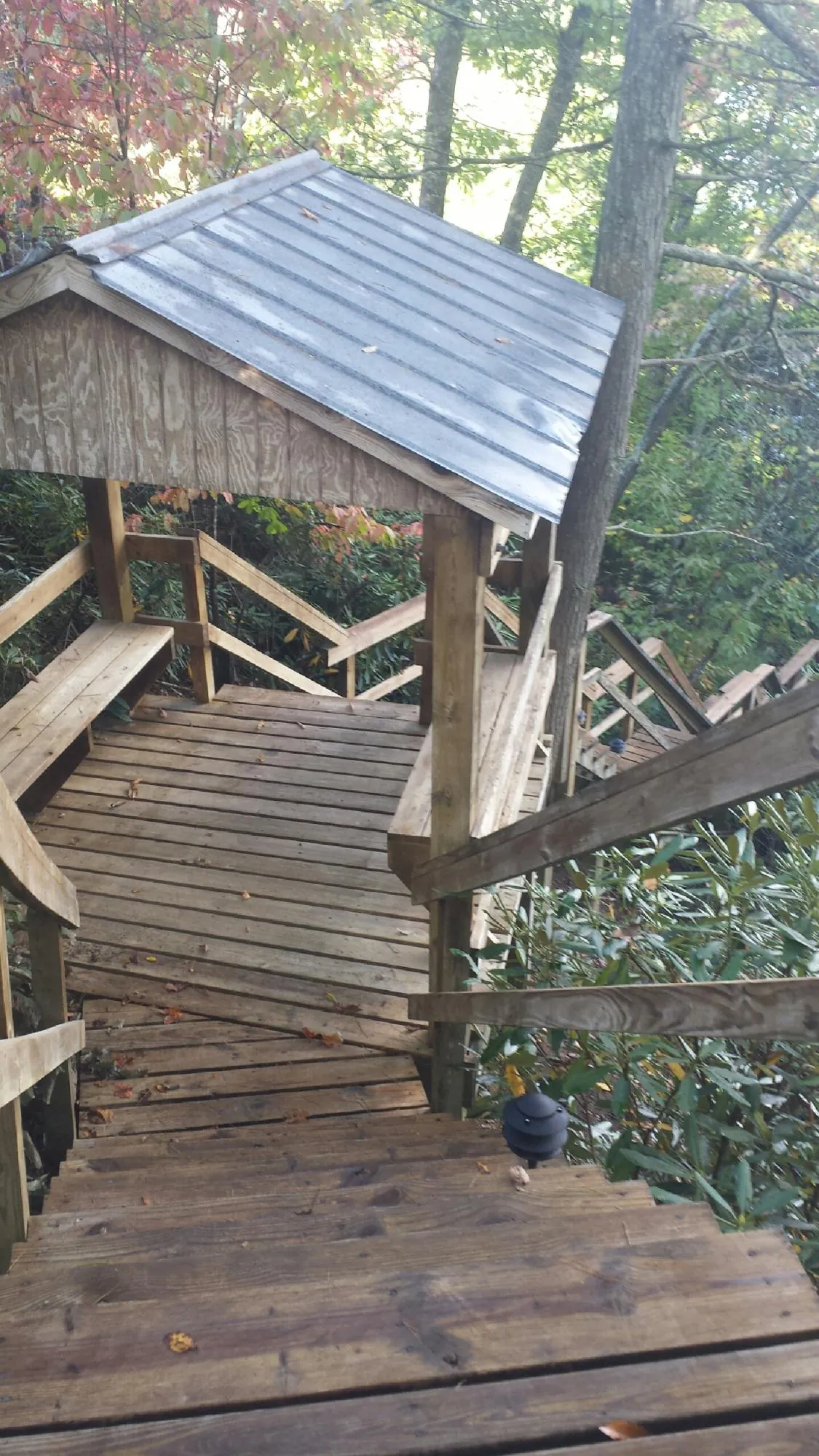 Metal roofed shelter over wooden steps on a wooded walkway — Skylight Repair & Installation work by our crew in Idaho Falls