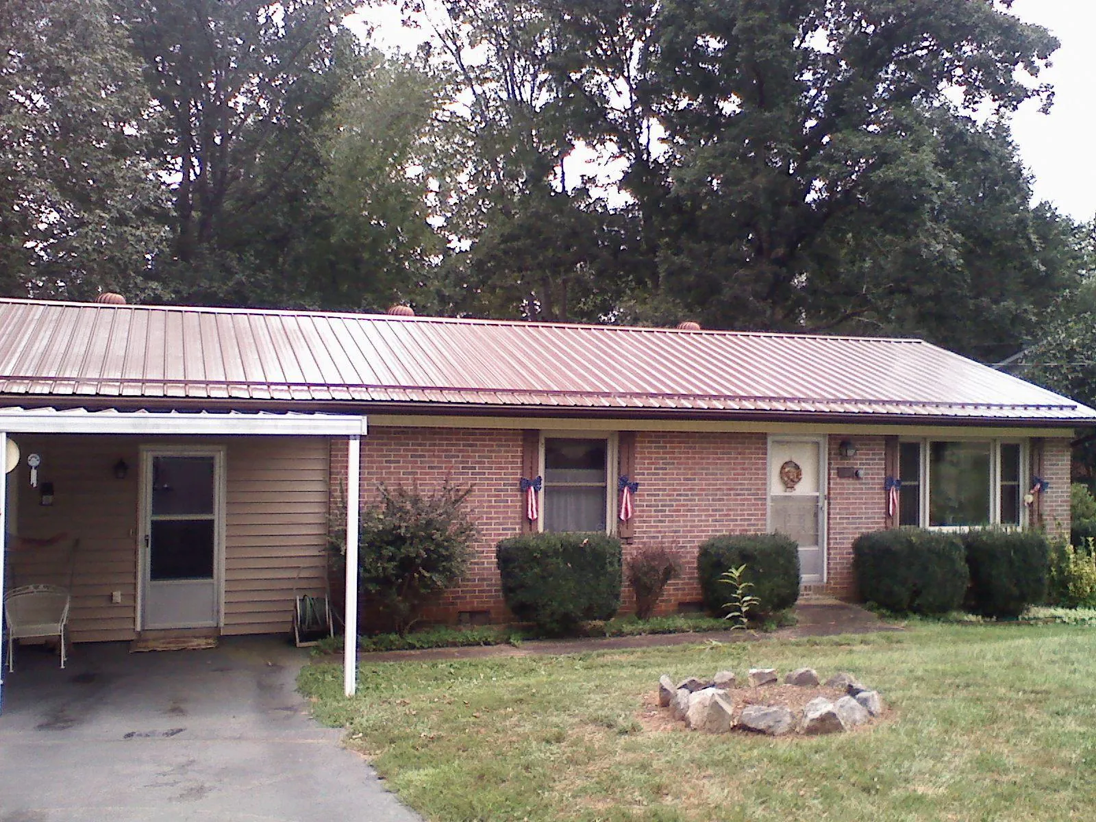 Bronze metal roof and carport on a brick ranch home — Roof Repair work by our crew in Idaho Falls
